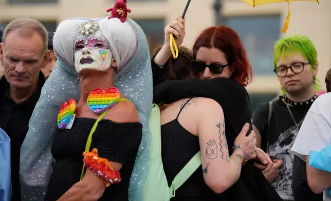 People gather outside the Brandenburg Gate for a demonstration in support of LGBTQ+ after a car rammed into a crowd at the Pride March in Berlin, Sunday, July 26, 2026. (AP Photo/Ebrahim Noroozi)