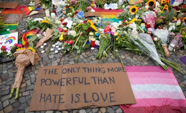 People leave flowers and notes outside the Brandenburg Gate for a demonstration in support of LGBTQ+ after a car rammed into a crowd at the Pride March in Berlin, Sunday, July 26, 2026. (AP Photo/Ebrahim Noroozi)