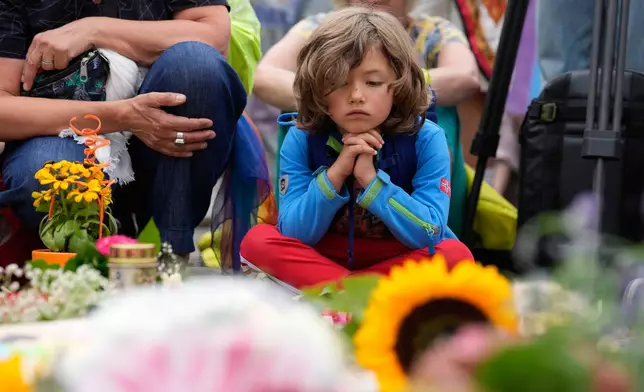People gather outside the Brandenburg Gate for a demonstration in support of LGBTQ+ after a car rammed into a crowd at the Pride March in Berlin, Sunday, July 26, 2026. (AP Photo/Ebrahim Noroozi)