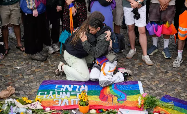 People gather outside the Brandenburg Gate for a demonstration in support of LGBTQ+ after a car rammed into a crowd at the Pride March in Berlin, Sunday, July 26, 2026. (AP Photo/Ebrahim Noroozi)