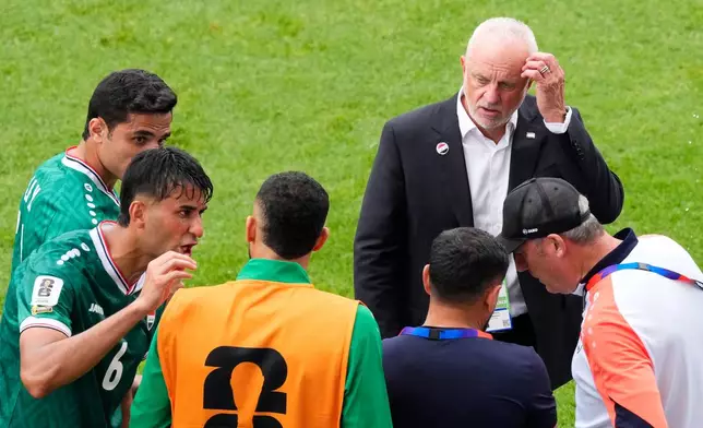 Iraq coach Graham Arnold, top right, speaks with his team during a hydration break in the World Cup Group I soccer match between Senegal and Iraq in Toronto, Friday, June 26, 2026. (Chris Young/The Canadian Press via AP)