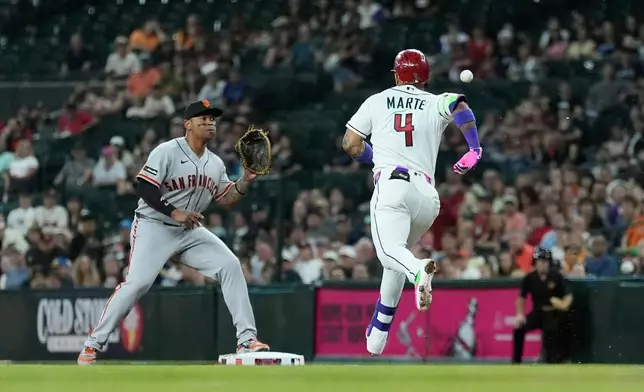 San Francisco Giants first baseman Rafael Devers, left, reaches out for the ball to get Arizona Diamondbacks' Ketel Marte (4) out at first base during the first inning of a baseball game, Tuesday, June 30, 2026, in Phoenix. (AP Photo/Ross D. Franklin)
