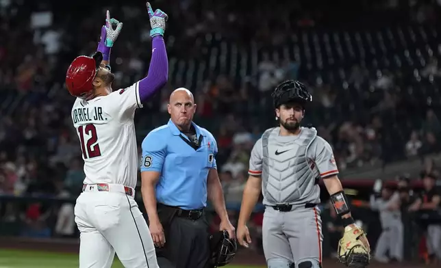 Arizona Diamondbacks' Lourdes Gurriel Jr. (12) celebrates his three-run home run as umpire Ryan Blakney and San Francisco Giants catcher Drew Cavanaugh (61) look on during the first inning of a baseball game, Tuesday, June 30, 2026, in Phoenix. (AP Photo/Ross D. Franklin)