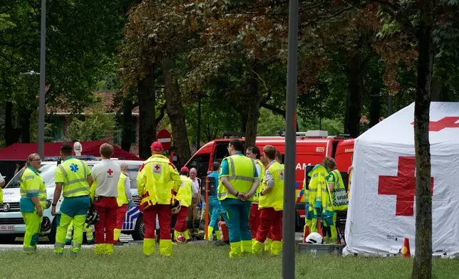 Rescue workers wait by a tent to receive injured after an apartment block fire in Linkeroever, Belgium, Wednesday, July 1, 2026. (AP Photo/Virginia Mayo)