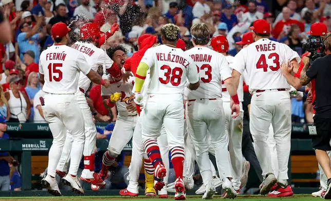 St. Louis Cardinals' Iván Herrera is mobbed by teammates as they celebrate his walk-off double during the tenth inning of a baseball game against the Chicago Cubs, Wednesday, July 29, 2026, in St. Louis. (AP Photo/Scott Kane)