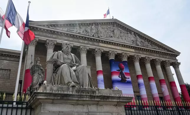 The French National Assembly is draped with the artwork "Marianne rêve" ("Marianne Dreams") by French street artist Seth, depicting Marianne the symbol of the French Republic, before lawmakers vote later on final approval of a bill allowing adults with incurable illnesses to receive lethal medication, in Paris, Wednesday, July 15, 2026. (AP Photo/Michel Euler)
