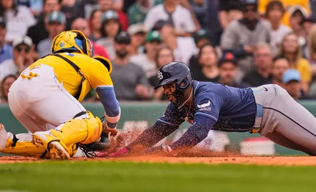 Tampa Bay Rays' Yandy Díaz, right, is tagged out by Boston Red Sox's Carlos Narváez, left, while trying to score on a double hit by Jonny DeLuca in the fourth inning of a baseball game, Saturday, July 18, 2026, in Boston. (AP Photo/Charles Krupa)