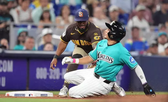 Miami Marlins' Javier Sanoja is tagged out short of third base by San Diego Padres third baseman Luis Rengifo during the seventh inning of a baseball game, Sunday, July 26, 2026, in Miami. (AP Photo/Rebecca Blackwell)