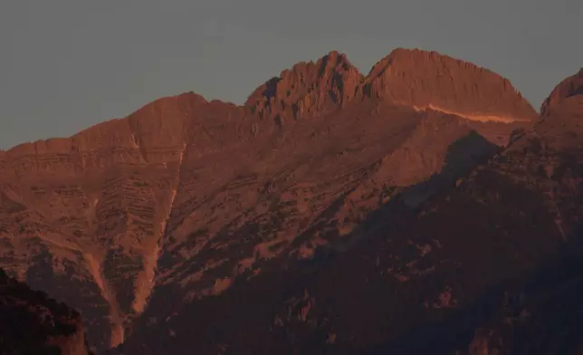 The morning light shines on Mytikas, Greece's highest peak, center left, and Stefani, known as the Throne of Zeus, center right, atop Mount Olympus seen from the outskirts of Litochoro in northern Greece, Wednesday, July 15, 2026. (AP Photo/Petros Giannakouris)