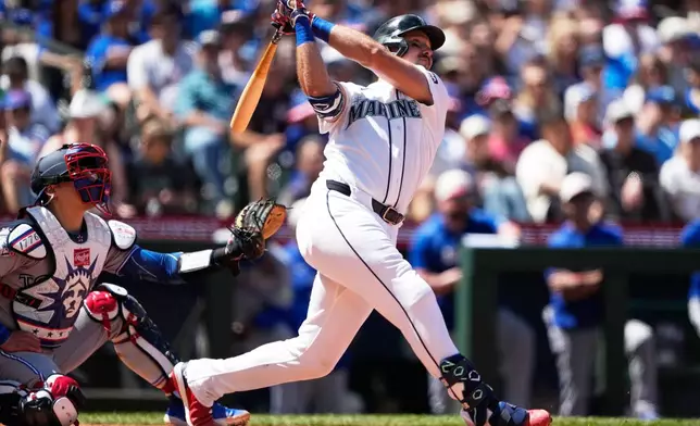 Seattle Mariners' Cal Raleigh follows through on a three-run home run against the Toronto Blue Jays during the sixth inning of a baseball game, Saturday, July 4, 2026, in Seattle. (AP Photo/Lindsey Wasson)