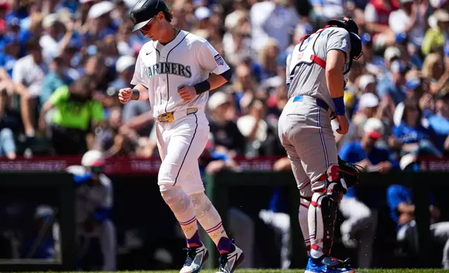 Seattle Mariners' Colt Emerson scores on an RBI single from Dominic Canzone as Toronto Blue Jays catcher Brandon Valenzuela looks away during the sixth inning of a baseball game, Saturday, July 4, 2026, in Seattle. (AP Photo/Lindsey Wasson)