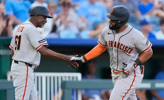 San Francisco Giants' Heliot Ramos celebrates with third base coach Gary Pettis (81) after hitting a solo home run during the fourth inning of a baseball game against the Kansas City Royals, Monday, July 20, 2026, in Kansas City, Mo. (AP Photo/Charlie Riedel)