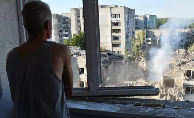 A man watches as rescuers clear the rubble at the damaged apartment building in a residential neighbourhood following a Russian air attack in Lviv, Ukraine, Thursday, July 30, 2026. (AP Photo/Mykola Tys)