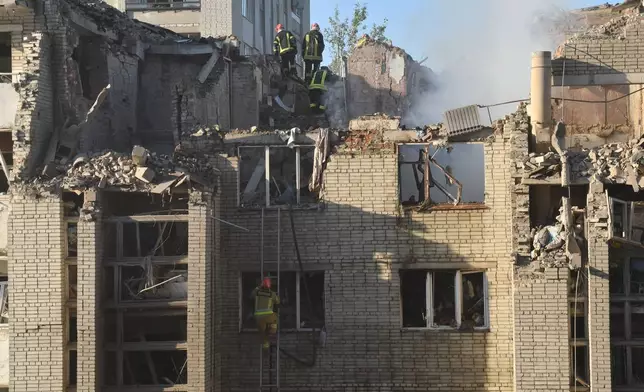 Rescuers search through the rubble of a residential building following air attack in Lviv, Ukraine, Thursday, July 30, 2026. (AP Photo/Mykola Tys)