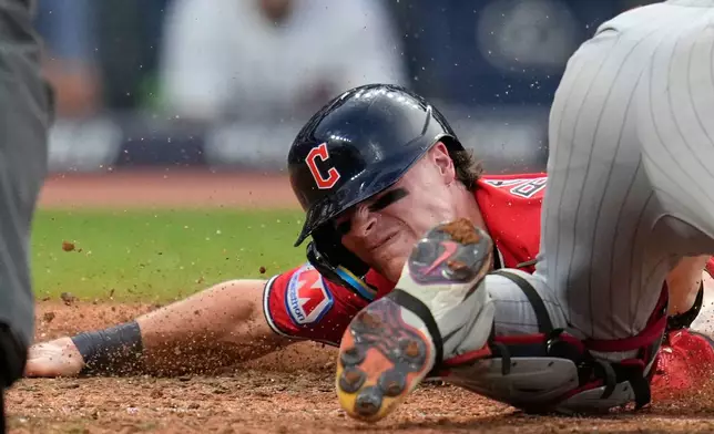 Cleveland Guardians' Travis Bazzana, left, scores under the tag of Minnesota Twins catcher Ryan Jeffers, right, in the sixth inning of a baseball game in Cleveland, Tuesday, July 21, 2026. (AP Photo/Sue Ogrocki)