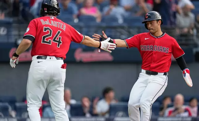 Cleveland Guardians' Steven Kwan, right, is congratulated by Chase DeLauter (24) after scoring in the third inning of a baseball game against the Minnesota Twins in Cleveland, Tuesday, July 21, 2026. (AP Photo/Sue Ogrocki)