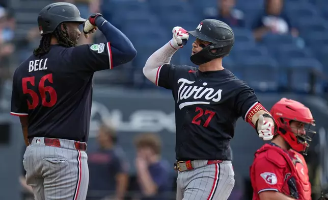 Minnesota Twins' Ryan Jeffers (27) celebrates his home run with Josh Bell (56) in the first inning of a baseball game against the Cleveland Guardians in Cleveland, Tuesday, July 21, 2026. (AP Photo/Sue Ogrocki)