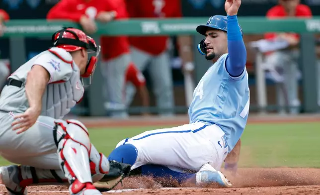 Kansas City Royals' Jac Caglianone, right, beats the tag by Philadelphia Phillies catcher J.T. Realmuto to score off a Nick Loftin double during the first inning of a baseball game in Kansas City, Mo., Monday, July 6, 2026. (AP Photo/Colin E. Braley)