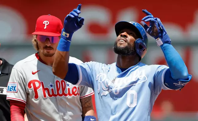 Kansas City Royals' Starling Marte (0) reacts next to Philadelphia Phillies second baseman Bryson Stott (5) after hitting a RBI double during the first inning of a baseball game in Kansas City, Mo., Monday, July 6, 2026. (AP Photo/Colin E. Braley)