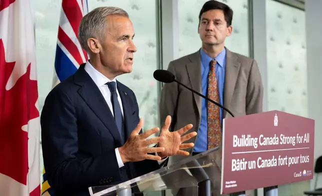 Prime Minister Mark Carney speaks accompanied by British Columbia Premier David Eby, right, in Vancouver, on Thursday, July 2, 2026. (Ethan Cairns/The Canadian Press via AP)