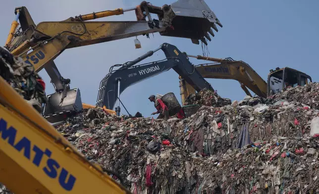A waste picker looks for recyclable items in a pile of garbage at the Bantargebang landfill on the outskirts of Jakarta, Indonesia, Monday, July 6, 2026. (AP Photo/Tatan Syuflana)