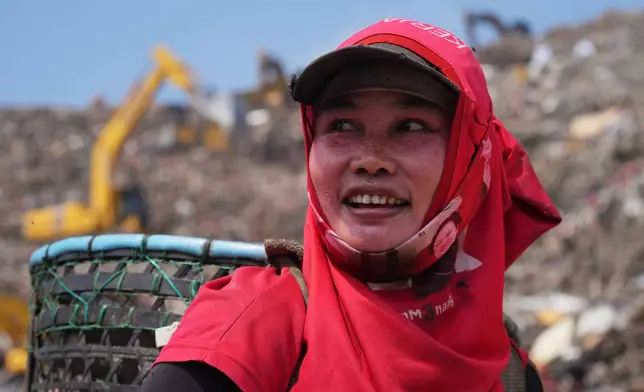 Nur Wencih, a waste picker, walks past at the Bantargebang landfill on the outskirts of Jakarta, Indonesia, Monday, July 6, 2026. (AP Photo/Tatan Syuflana)