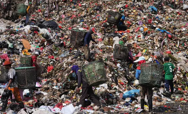 Waste pickers look for recyclable items in a pile of garbage at the Bantargebang landfill on the outskirts of Jakarta, Indonesia, Monday, July 6, 2026. (AP Photo/Tatan Syuflana)