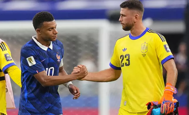 France's Kylian Mbappe (10) and Spain goalkeeper Unai Simon (23) shake hands after the World Cup semifinal soccer match between France and Spain in Arlington, Texas, near Dallas, Tuesday, July 14, 2026. (AP Photo/Julio Cortez)
