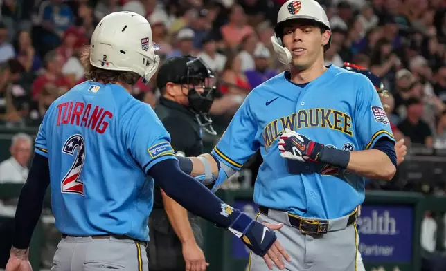 Milwaukee Brewers' Brice Turang, left, greets Christian Yelich, right, after Yelich's two-run home run in the fifth inning during their game against the Arizona Diamondbacks, Saturday, July 4, 2026, in Phoenix. (AP Photo/Darryl Webb)