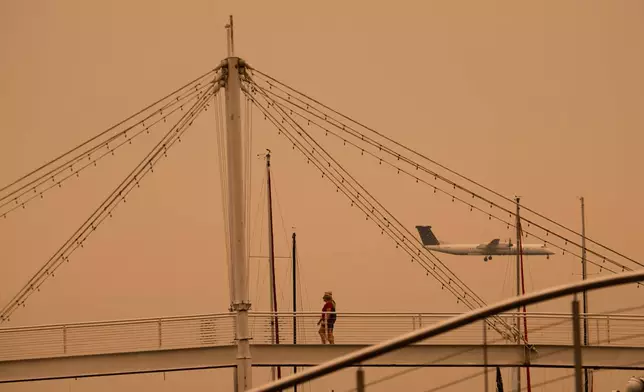 A plane lands at Billy Bishop Toronto City Airport as wildfire smoke fills Toronto, on Wednesday, July 15, 2026. (Laura Proctor/The Canadian Press via AP)