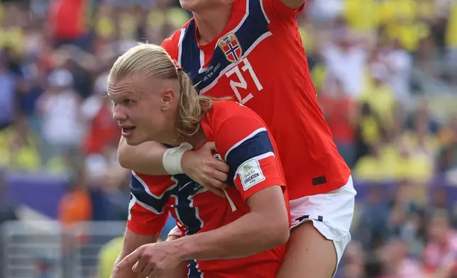 Norway's Erling Haaland (9) celebrates with Andreas Schjelderup (21) after scoring their second goal during the World Cup round of 16 soccer match between Brazil and Norway in East Rutherford, N.J., near New York, Sunday, July 5, 2026. (AP Photo/Pamela Smith)
