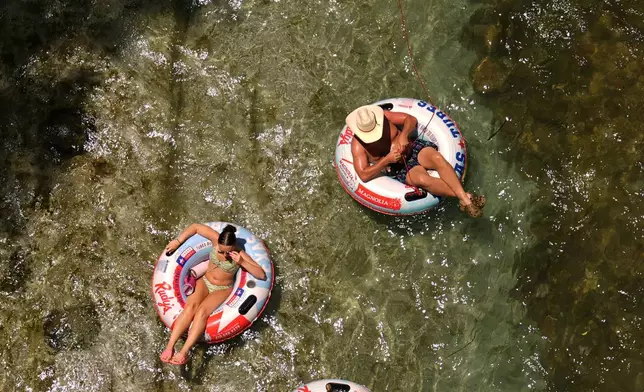 Tubers float along the cool waters of the Comal River in New Braunfels, Texas, Wednesday, July 1, 2026. (AP Photo/Eric Gay)