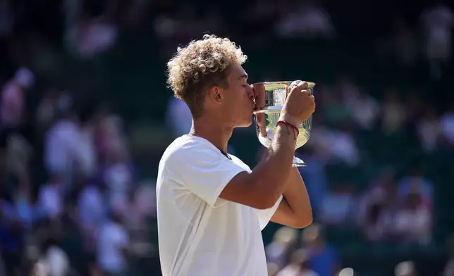 Jordan Lee of the United States kisses the trophy after winning against Cruz Hewitt of Australia in the boy's singles final at the Wimbledon Tennis Championships in London, Sunday, July 12, 2026. (AP Photo/Brian Inganga)
