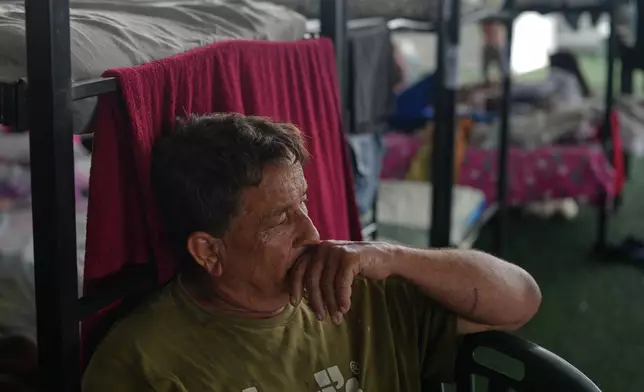 Javier Contreras sits at a sports center sheltering people displaced by the earthquakes in La Guaira, Venezuela, Thursday, July 9, 2026. (AP Photo/Ariana Cubillos)