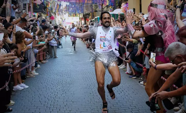 Participants wearing shoes with heels of at least 10 centimeters (3.9 inches) run in the annual high heel race during Madrid's Pride week, in Madrid, Thursday, July 2, 2026. (AP Photo/Andrea Comas)