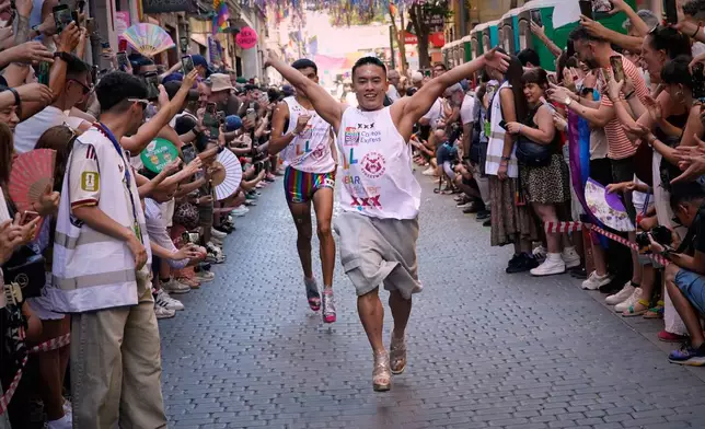 Participants wearing shoes with heels of at least 10 centimeters (3.9 inches) run in the annual high heel race during Madrid's Pride week, in Madrid, Thursday, July 2, 2026. (AP Photo/Andrea Comas)