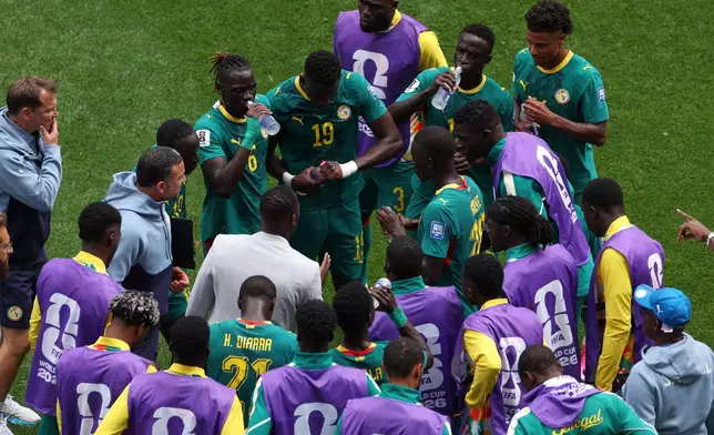 Senegal head coach Pape Thiaw, center, instructs his players during a hydration break during the World Cup round of 32 soccer match against Belgium in Seattle, Wednesday, July 1, 2026. (AP Photo/Maddy Grassy)