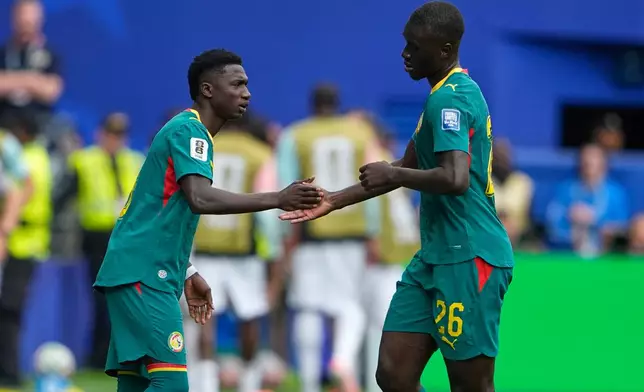 Senegal's Pape Gueye (26) shakes hands with Senegal's Lamine Camara after being substituted during the World Cup round of 32 soccer match between Belgium and Senegal in Seattle, Wednesday, July 1, 2026. (AP Photo/Lindsey Wasson)