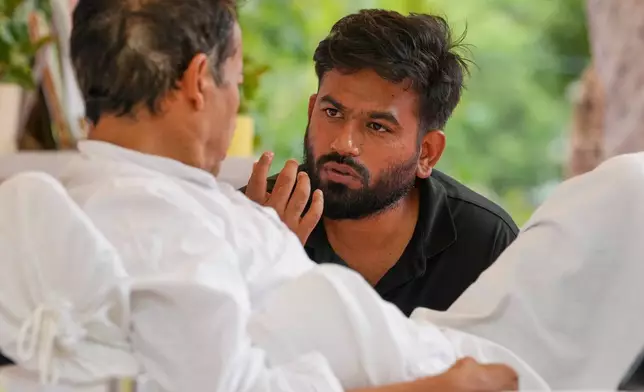 Abhijeet Dipke, founder of the Cockroach Janta Party, center, talks climate activist Sonam Wangchuk, who is undertaking an indefinite hunger strike during a protest demanding the resignation of Education Minister Dharmendra Pradhan over alleged examination irregularities and repeated paper leaks in New Delhi, India, on July 10, 2026. (AP Photo/Manish Swarup)