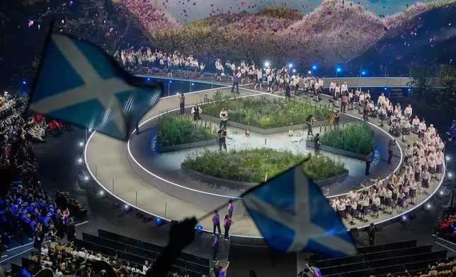 Scottish flags are waved by fans as the Scotland team arrives on stage during the Commonwealth Games opening ceremony in Glasgow, Scotland, Thursday, July 23, 2026. (AP Photo/Manish Swarup)