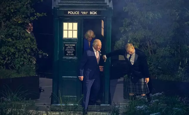 Britain's King Charles III, centre, steps out of the the Dr Who Tardis police box as he arrives at the start of the Commonwealth Games opening ceremony in Glasgow, Scotland, Thursday, July 23, 2026. (AP Photo/Manish Swarup)