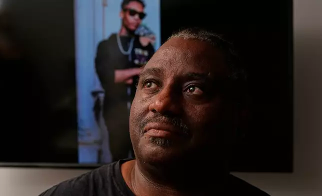 Evaniel Johnson poses with a picture of his grandson, Tyrin Johnson, Monday, July 6, 2026, in Nashville, Tenn., after his grandson was fatally shot by two Tennessee National Guard members in Memphis on Sunday, morning. (AP Photo/George Walker IV)