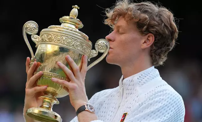 Jannik Sinner of Italy kisses the winners trophy after defeating Alexander Zverev of Germany in the men's singles final at Wimbledon Tennis Championships in London, Sunday, July 12, 2026. (AP Photo/Kin Cheung)