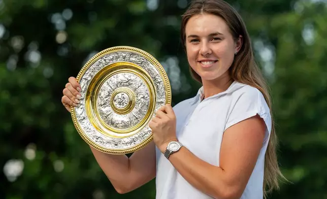 Linda Noskova of Czech Republic poses with the winner's trophy of the Wimbledon Tennis women's singles tournament, during a news conference in Prague, Monday, July 13, 2026. (Ondrej Deml/CTK via AP)