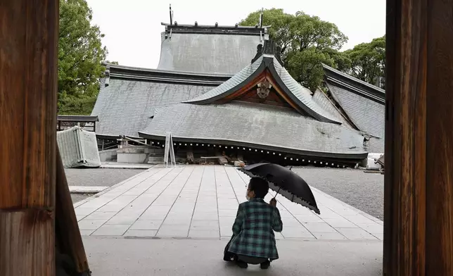 A visitor looks at the fallen roofs of the Yatsuhiro Shrine, a day after an earthquake in Yatsushiro, Kumamoto prefecture, Wednesday, July 29, 2026.(Juntaro Yokoyama/Kyodo News via AP)