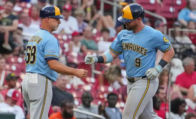 Milwaukee Brewers' Jake Bauers (9) is congratulated by third base coach Matt Erickson after hitting a three-run home run during the third inning of a baseball game Thursday, July 9, 2026, in St. Louis. (AP Photo/Jeff Roberson)