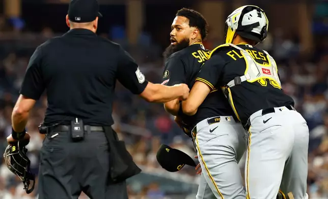 Pittsburgh Pirates catcher Rafael Flores Jr. keeps pitcher Dennis Santana from going after New York Yankees' José Caballero during the ninth inning of a baseball game, Monday, July 20, 2026 in New York. (AP Photo/Noah K. Murray)