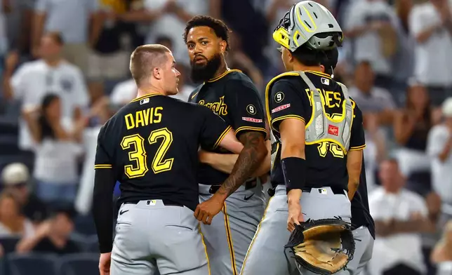 Pittsburgh Pirates catchers Henry Davis (32) and Rafael Flores Jr. keep pitcher Dennis Santana from going after New York Yankees' José Caballero during the ninth inning of a baseball game, Monday, July 20, 2026 in New York. (AP Photo/Noah K. Murray)