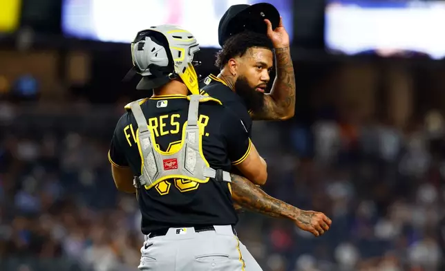 Pittsburgh Pirates catcher Rafael Flores Jr. keeps pitcher Dennis Santana from going after New York Yankees' José Caballero during the ninth inning of a baseball game, Monday, July 20, 2026 in New York. (AP Photo/Noah K. Murray)