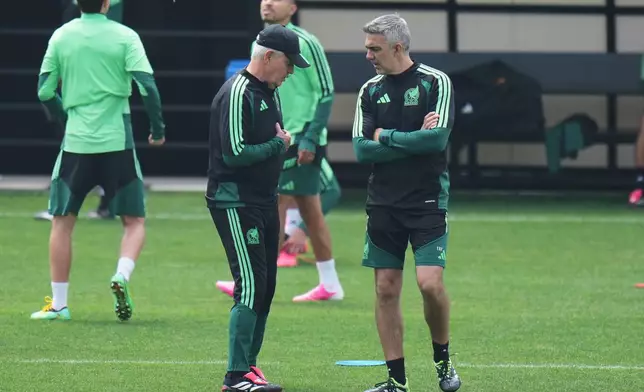 Mexico head coach Javier Aguirre, left, talks with his assistant Toni Amor during a training session ahead of their World Cup round of 16 soccer match against England in Mexico City, Saturday, July 4, 2026. (AP Photo/Eduardo Verdugo)
